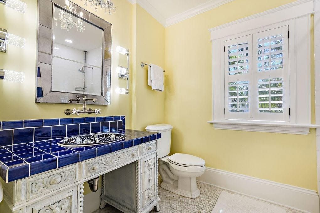 The same bathroom finished with a carved vanity and hand-painted sink
