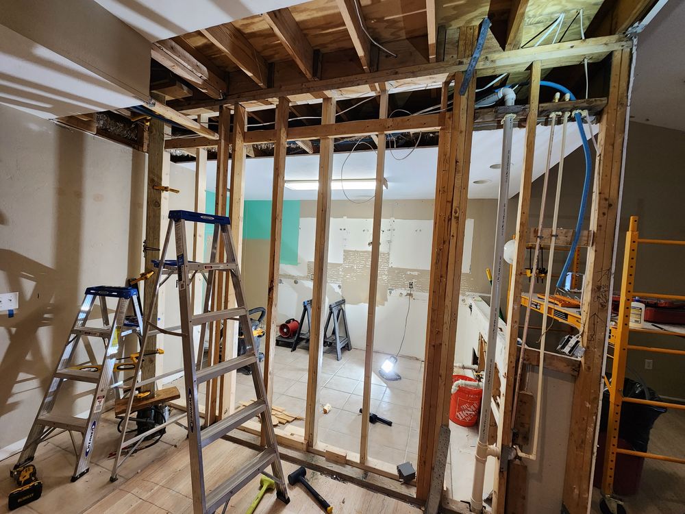 New wall framing with an open ceiling, ladders, and scaffold