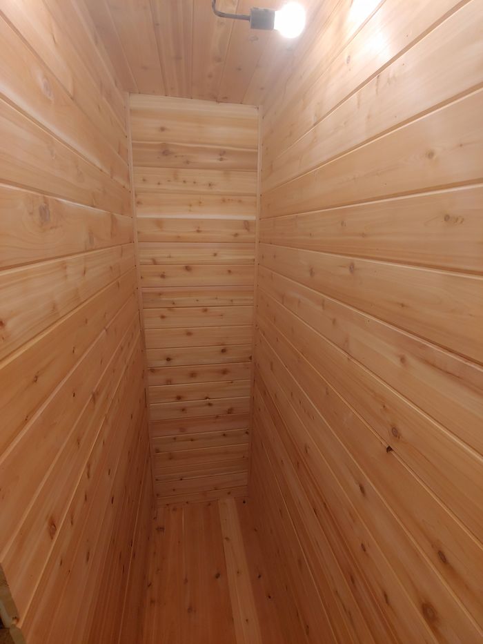 Closet lined floor to ceiling in cedar planks