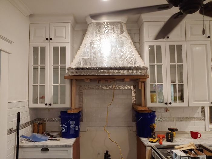 Mosaic range hood framed in wood