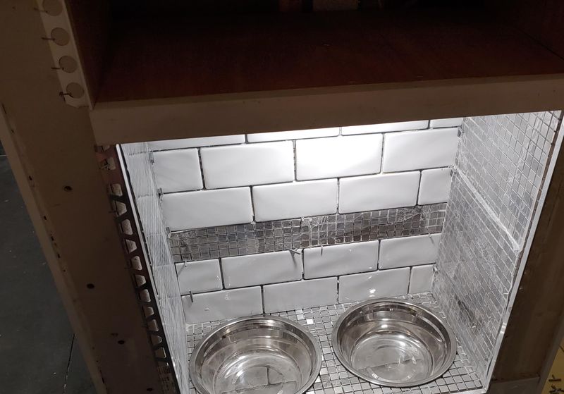 Tiled niche with two steel pet bowls built into the island